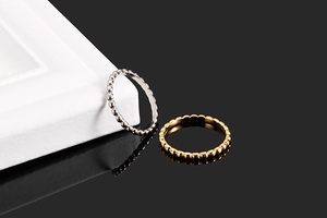 Detail of beaded minimalist rings in gold and silver finish on a modern geometric setup