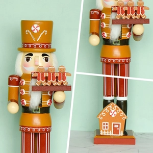 Gingerbread nutcracker chef figure in yellow and red with candy house details
