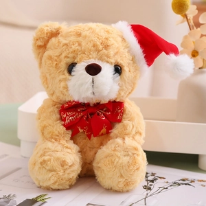 Detailed view of brown teddy bear with red Christmas hat and Merry Christmas bow