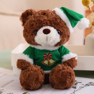 Detail of a brown plush teddy bear wearing a green Christmas sweater and matching hat