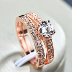 Rose gold engagement ring set with large round CZ and pavé bands on velvet stand