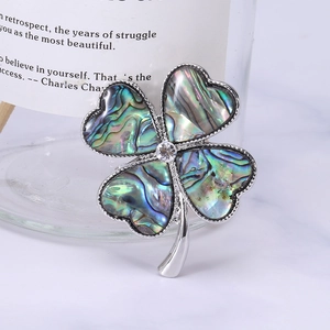 Elegant four-leaf clover brooch with iridescent shell petals and central rhinestone inlay