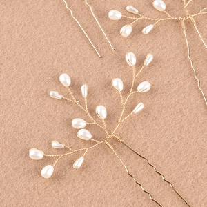 Détail d'épingle à cheveux de mariée artisanale avec fils dorés et perles sur fond beige