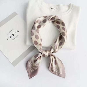 Elegant polka dot satin silk scarf in beige and brown tied in a stylish knot