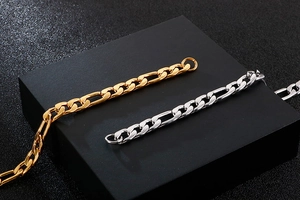 Detailed macro view of gold and silver Figaro stainless steel chains on a black base