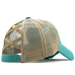 Detail of teal and beige criss-cross elastic ponytail hole on washed mesh baseball cap