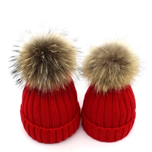 Parent-child red knitted beanies with large natural fur pom-poms for winter warmth