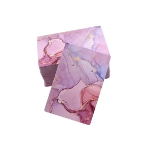 Macro shot of marble textured jewelry display cards with gold accents on white background
