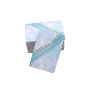 Macro shot of marble-patterned earring display cards with blue and silver glitter