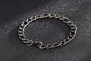 Macro detail of vintage stainless steel Cuban link bracelet with lobster clasp