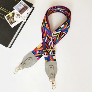 Close-up of adjustable ethnic style bag strap with colorful weave and gold metal hooks