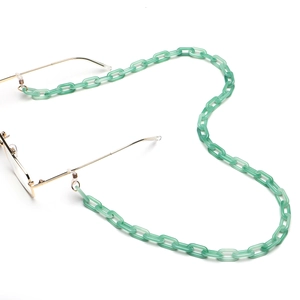 Dettaglio della catena per occhiali in acrilico verde chiaro con anelli d'oro e maglie
