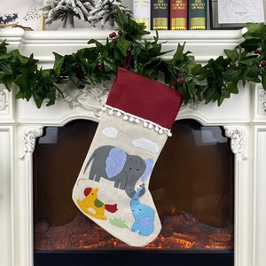 Christmas stocking with elephant applique hanging on a festive decorated fireplace mantel