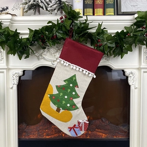 Christmas gift stocking with green tree patch hanging on a white fireplace mantle