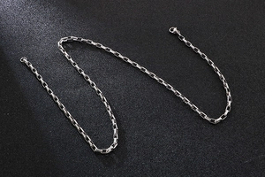 Macro detail of silver rectangle box chain links with polished stainless steel finish