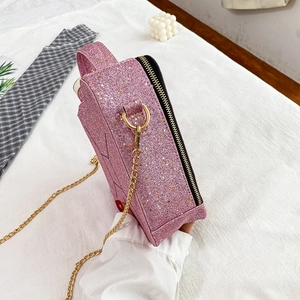Close-up of pink sequin handbag with gold chain strap and reflective glitter texture