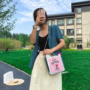 Outdoor model holding silver sequin oil drum bag with BAD BITCH FUEL embroidery