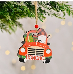 Detailed view of a red wooden truck ornament with a gnome hanging on a Christmas tree