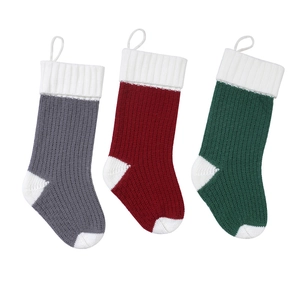 Set of three large knitted Christmas stockings in red, grey, and green with white cuffs