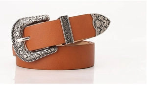 Close-up of camel leather belt featuring silver bohemian floral embossed buckle and tip