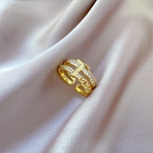 Adjustable gold plated open ring with T-cross zircon chain design on purple silk fabric
