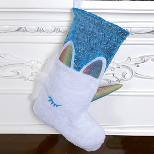 White plush unicorn Christmas stocking with blue sequins on a festive white fireplace mantel