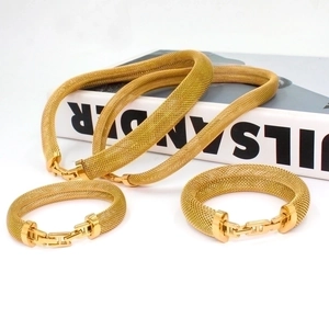 Detailed view of gold woven mesh jewelry set with H-shaped clasp and thick texture