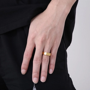 Close-up of a minimalist wide flat-top gold stainless steel ring for men being worn