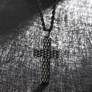 Macro shot of black cross pendant with woven texture on a twisted rope chain