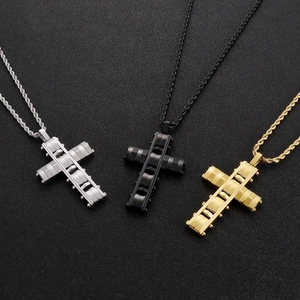 Detail of three stainless steel cross pendants in silver, black, and gold on braided chains