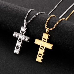 Detailed macro view of mechanical style cross pendants in gold and silver sandblasted finishes