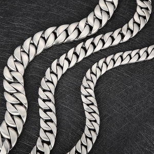 Three sizes of frosted stainless steel Cuban link chains with bone buckle on black background