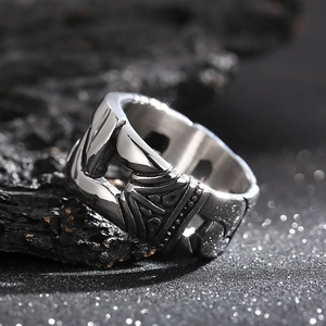 Macro shot of silver punk ring with chain texture and geometric relief on dark charcoal