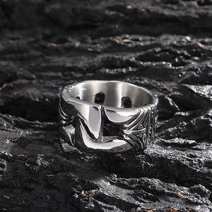 Macro shot of men's vintage titanium steel chain ring on a textured black rock background
