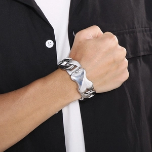 Close-up of polished silver cuban link bracelet with geometric bone-shaped clasp