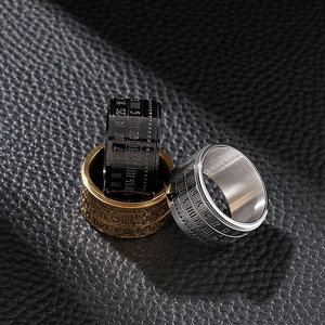Detailed close-up of three rotating titanium steel calendar rings in gold, silver, and black
