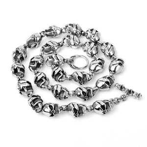 Macro detail of punk skull pendant and metallic chain texture on white background