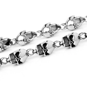 Detailed view of silver metal skull-shaped links on a punk style mens chain necklace