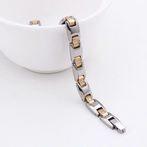 Macro detail of two-tone stainless steel magnetic bracelet with crystals and clasp