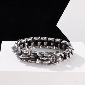 Detailed close-up of punk dragon scale bracelet with antique finish on a white stand