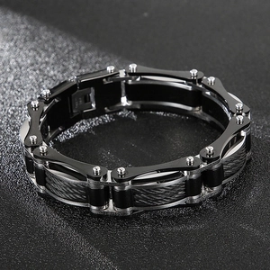 Detail of mechanical bike chain bracelet featuring black and silver steel cable