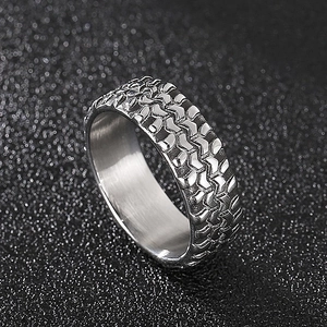 Macro detail of men's stainless steel ring showing tire tread texture and silver finish