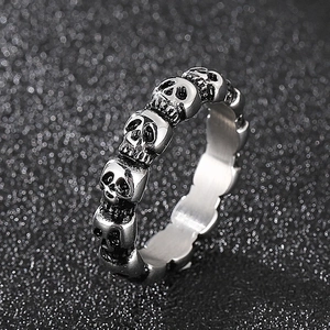Detailed close-up of retro silver skull ring with gothic punk engravings and textured finish