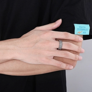 Close-up of vintage steel men's ring with textured tire pattern and retro silver finish