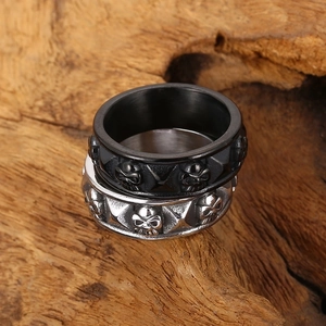Vintage gothic skull rings in matte black and silver steel on rustic wood