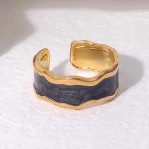 Detail of wave texture and dark gray enamel inlay on the golden stainless steel ring
