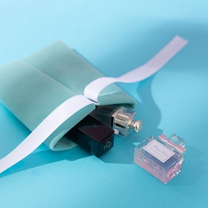 Mint green velvet jewelry pouch with smooth white satin ribbon on a light blue background
