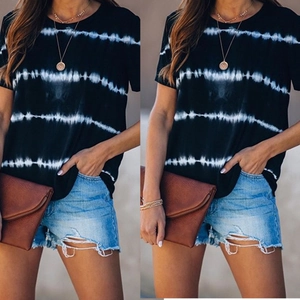 Détail d'un t-shirt à rayures tie-dye noir et blanc avec short en jean et pochette foncée