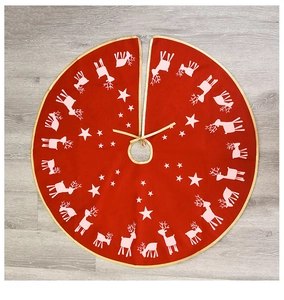 Macro detail of red linen Christmas tree skirt with reindeer and stars on wood floor