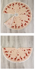 Detailed close-up of burlap Christmas tree skirt with reindeer print and white ties